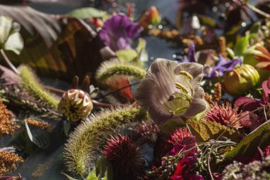 Suyun üzerinde güzel bir çiçek kompozisyonu. Farklı çiçek ve bitkilerden oluşan muhteşem bir buket. Düğün kompozisyonu.