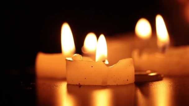 Groupe de bougies brûlant dans un environnement sombre.