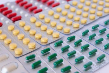 Gümüş su toplayan hap paketleri tipe, renge ve boyuta göre sıralanmış, seçici bir odak ile. Farklı hastalıklar için ilaçlar.