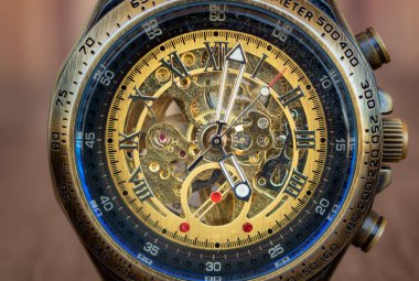 Bronz, çelik, lacivert iç halkalı Steampunk tarzı kol saati. Saatin dahili makinesini görebilirsiniz. mavi arkaplan.