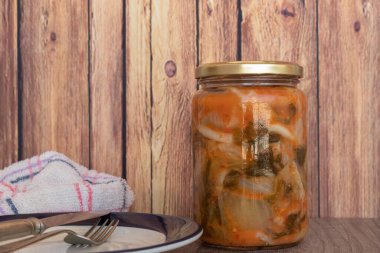 Kimçi lahana kavanozu, tipik baharatlı Kore yemeği kırsal bir tabakta servis edilmeye hazır..