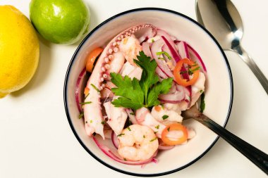 Tipik Peru yemeği, kalamar ceviche, karides ve mor soğanlı beyaz balık ve iyi bir kaplan sütü. Beyaz bir kasede servis edilmiş. Üst görünüm.