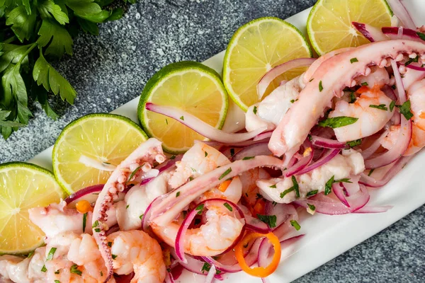 Tipik Peru yemeği, kalamar ceviche, karides ve mor soğanlı beyaz balık ve iyi bir kaplan sütü. Yemek servisi için sunulmuş. Yan görünüm.