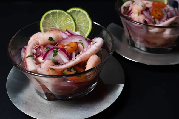 Tipik Peru yemeği, ceviche ile kalamar, karides ve beyaz balık ile mor soğan ve iyi bir kaplan sütü. Koyu arkaplanda cam bir konteynırda servis edilmiş. Gurme konsepti, zarafet