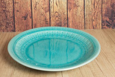 Ahşap masada boş turkuaz bir tabak. Yanal görüş. yakın plan