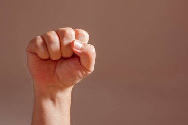 Beyaz bir adamın sıkı yumruğu yüksekte duruyor. Direniş, dayanışma ve meydan okuma kavramı.