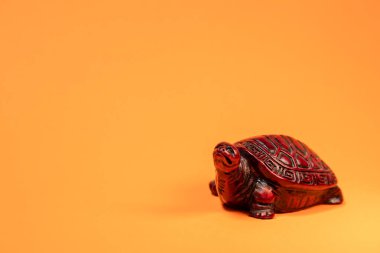 Terra cotta renkli Afrika kaplumbağası yürüyüşünün küçük bir heykeli.