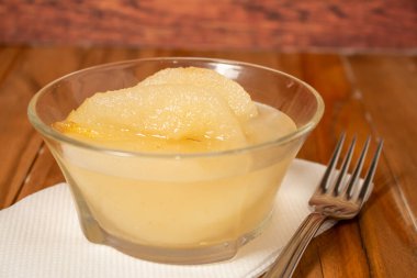 Tatlı şurupla servis edilmiş taze armutlar. Ahşap arkaplan.