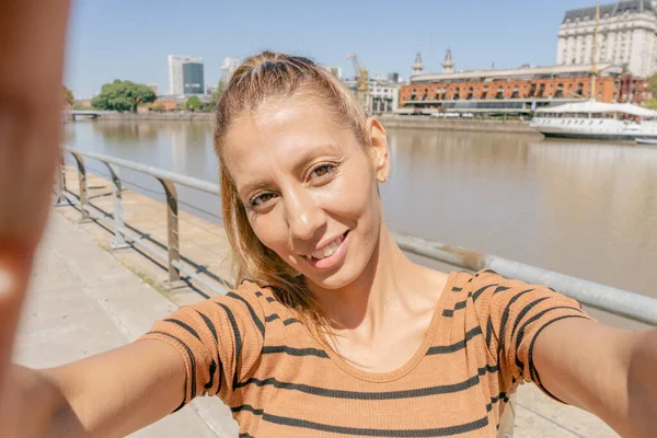 Attractive Latin woman doing a very funny selfie with her smartphone. Modern and funny woman concept