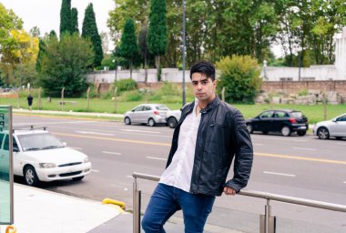 Siyah ceketli, kot pantolonlu ve beyaz gömlekli çekici bir Latin..