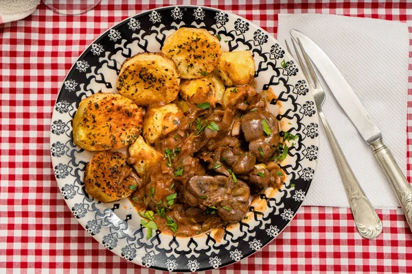 Biftek böbreği, pırasa ve soğan yahnisi, İspanyol usulü patatesler.