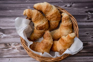 Bir tavada kruvasan veya ekmek sepetinde kruvasan parçaları ve ekmek kırıntıları masanın üzerinde..