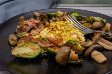 Portobello ve mantarlı Brüksel lahanası, domuz pastırması ve çırpılmış yumurta..