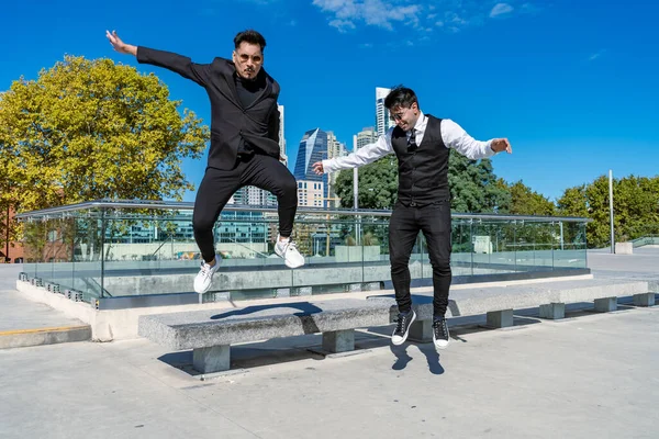 Jovens Hispânicos Divertindo Pulando Banco Parque Público Desgaste Formal — Fotografia de Stock