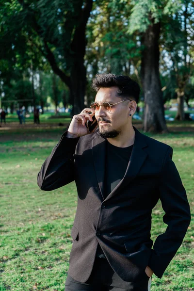 Молодой Латиноамериканец Разговаривает Телефону Общественном Парке Время Прогулки Вертикальный Вид — стоковое фото