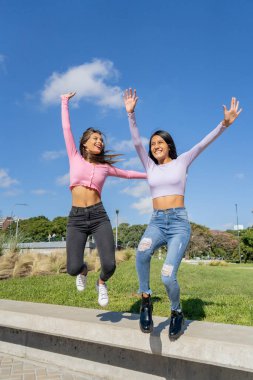 İki güzel genç kadın şehirde zıplıyor ve dans ediyor.