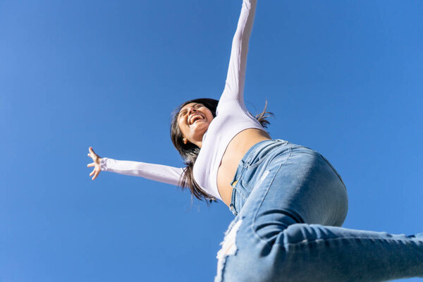 One beautiful young woman jumping and dancing in the city