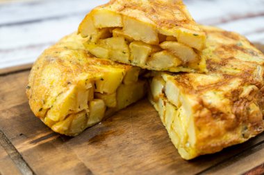 Tipik bir İspanyol patatesi ya da patates omletinin kırsal bir ortamda kesilen bir kısmına yakın plan. İspanyol Mutfağı.