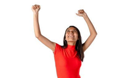 Çekici, gülümseyen, koyu renk saçlı, kolları açık, beyaz arka planda kişisel başarısını kutlayan Latin bir kadın..