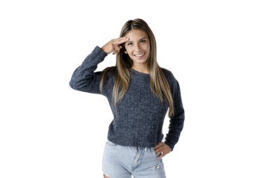 Güzel Latin kadın elini alnında sallayarak ve saf beyaz bir arka planda mutlu bir tavırla ileri bakıyor..