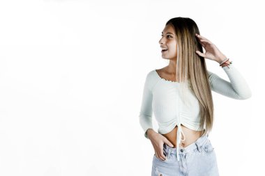 Saf beyaz bir arka planda mutlu bir tavırla sağa bakan güzel Latin kadın..