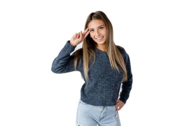 Güzel Latin kadın elini alnında sallayarak ve saf beyaz bir arka planda mutlu bir tavırla ileri bakıyor..