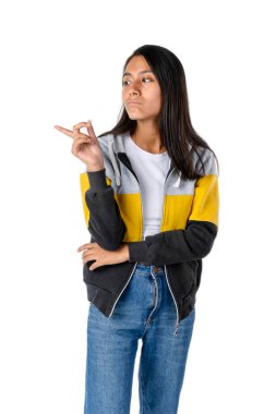 Çekici siyah düz saçlı Latin kadın saf beyaz bir arka planda suratının asık olduğu tarafı işaret ediyor..