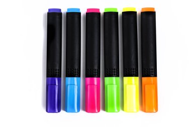 Beyaz arkaplandaki renklere göre sıralanmış fosforlu kalemler kümesi.