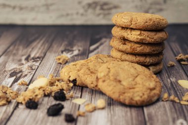 Masaya atılmış kuru üzümlü, tohumlu, kuru üzümlü ve mısır gevrekli ev yapımı yulaflı kurabiyeler yığını. Doğal ve organik beslenme kavramı.