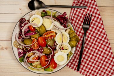 Sağlıklı ve besleyici marul salatası, kiraz domatesi, yumurta, salatalık ve susam tohumlu kırmızı soğan. Yatay yönelim