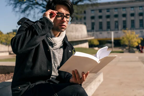 Homem Sentado Banco Concreto Parque Público Lendo Livro Tomando Uma — Fotografia de Stock