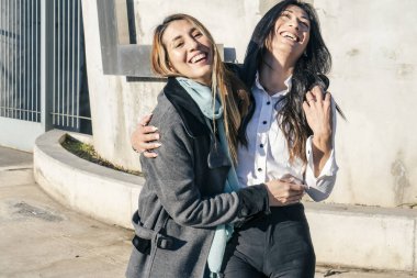 İki güzel gülümseyen ve kucaklaşan mutlu kadın. Neşe ve mutluluk kavramı.