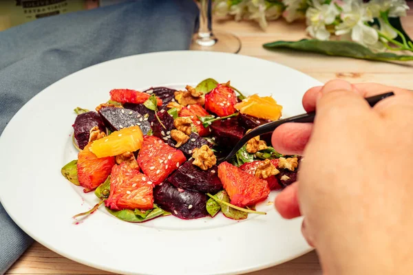 Mão Tomando Uma Porção Deliciosa Beterraba Laranja Noz Salada Arugula — Fotografia de Stock