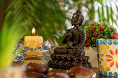 Buda heykeli, mumlar, bitkiler ve tesadüflerle meditasyon sunağı