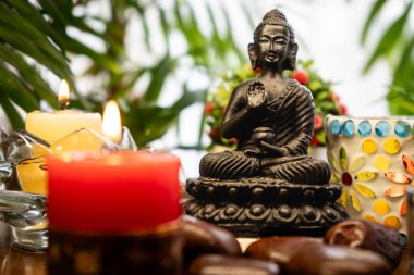 Buda heykeli, mumlar, bitkiler ve tesadüflerle meditasyon sunağı