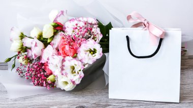 Çiçek paketleme servisi pembe beyaz arka plan hediye nakliyesi. Çiçekli güzel romantik kompozisyon. Sevgililer Günü geçmişi. Eko çanta hediyesi. Fotokopi alanı. Tatil kavramı