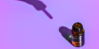 Mavi arka planda koyu gölgesi olan göz damlası şişesi. Modern yaratıcı minimalizm kavramı. Uzayı kopyala Serum teni