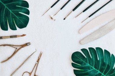 Manikür - manikür, jöle cilası, hepsi tırnak tedavisi için, güzellik konsepti için, beyaz havlu arka planında yeşil yapraklı özen. Yazı salonu afişi. Metin için alanı kopyala.