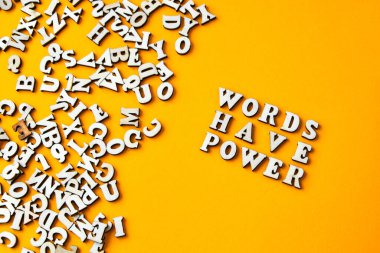 Alıntı kelimelerin parlak sarı arkaplandaki ahşap harflerden yapılmış bir gücü vardır. Motive edici Kelimeler Alıntılar Kavramı