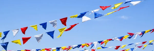 multi colored party rainbow flags on blue sky for celebration. Flags Colors Blue Sky. Color party flags festival