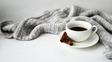Tarçın çubuklu kahve ve beyaz arka planda anason yıldızı. Etrafta süveter var. Kış sabahı rutini. Kahve molası. Uzayı kopyala Kahvaltı..