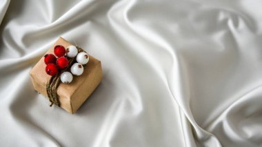 Şampanya renkli ipek arka planda süslemeleri olan sıfır ziyan Noel hediyesi. Uzayı kopyala Kartondan etiketli çevre dostu bir hediye. Yeni Yıl