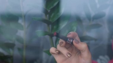 Kadın eli rujla pencereye kırmızı kalp çizer. Evde kal, her şey yolunda. Kalbinde sıcaklık var. Sevgililer Günü. Aşk