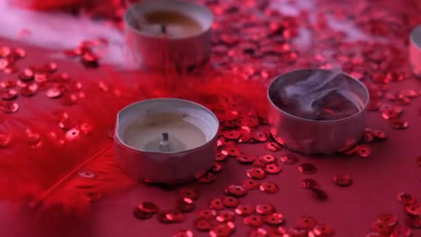 Un primo piano della candela accesa del tè che si spegne. Fumo. Primo piano di candela accesa tealight raggruppati su sfondo rosso. Atmosfera romantica con candele profumate aromatiche al tè. San Valentino — Video Stock