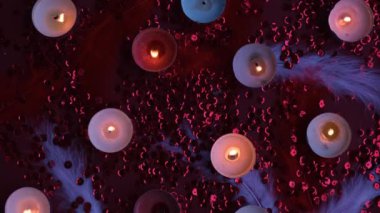 Kırmızı arkaplanda bir araya getirilmiş yanan mum üst görünümü. Kokulu çay mumlarıyla romantik bir atmosfer. Sevgililer Günü arkaplanı