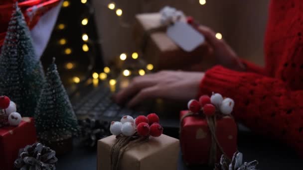 クリスマスオンラインショッピング、仕事と教育。テーブルの上で新年の装飾。自宅でノートパソコンを持つ女性。冬休み営業 — ストック動画