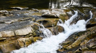 Dere kenarındaki büyük ve küçük taşlar. Dağlar. Taşın dokusu. Geçmişi. Su kayalara düşer. Doğada güzellik