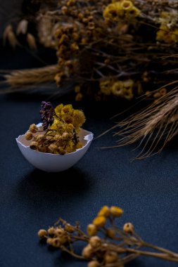 Paskalya bayramı. Kendiniz yapın. Moda Paskalya dekorasyonları. Kuru otlu organik yumurtalar ve tabakta kuru çiçekler. Kuş tüyü. Uzayı kopyala Tebrik kartı. Koyu arkaplan.