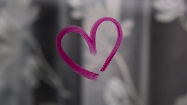 Сердце, нарисованное на стекле помадой. День Святого Валентина. Любовь и романтика. Сердце, нарисованное помадой. Окно. 4k Видео. Увеличь — стоковое видео