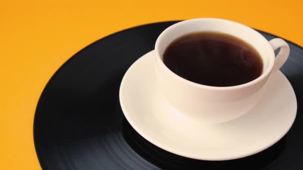 Egy csésze fekete kávé van a bakelitlemezen. Gőzölgő csésze kávé. — Stock videók